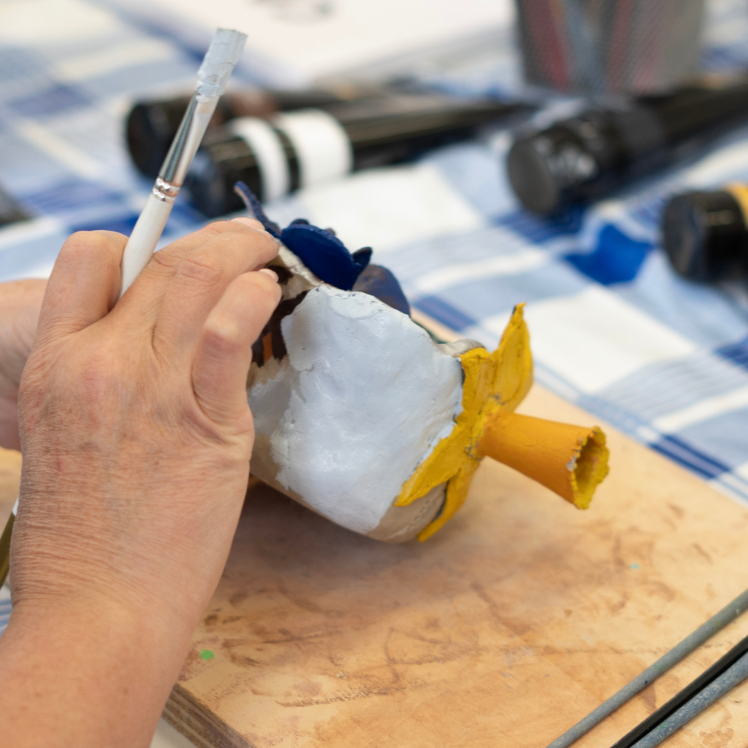 Someone's hands painting an object