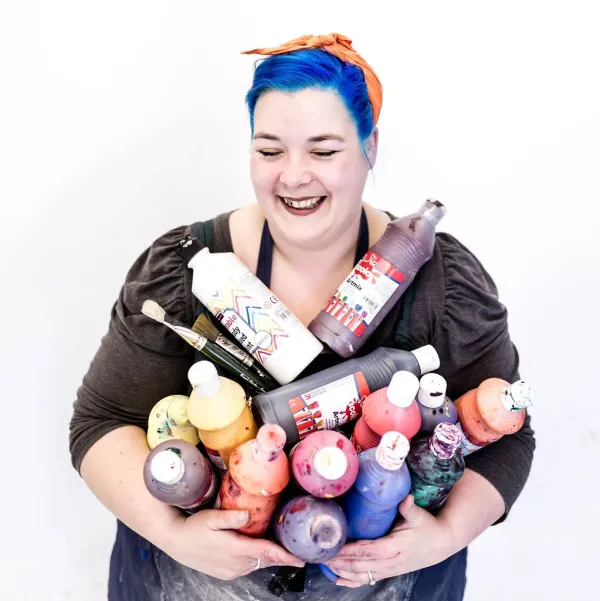 Artist clutching paint bottles